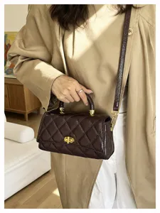 Vista dettagliata di una borsa a tracolla marrone trapuntata rétro con dettagli dorati, stile.