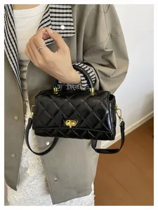 Borsa a tracolla trapuntata nera chic con chiusura a torsione dorata e manico retrò.