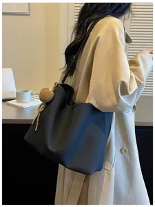 Detailed side view of women's minimalist large capacity shoulder tote bag for daily commute.