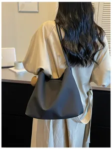 Shoulder tote bag detail view, casual dark design, daily commuting style wearing.
