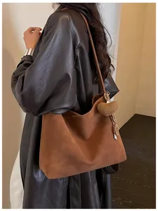 Chic brown vintage shoulder tote bag detail showcasing large capacity and heart pendant charm.
