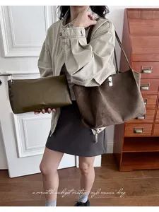 Detail shot of stylish suede tote and clutch set, vintage brown design for daily commuting.