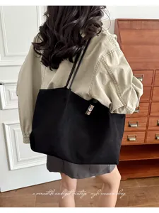 Detail shot of the black vintage tote bag showcasing its minimalist design and metal lock.