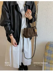 Vintage brown suede tote bag with flower pendant, detailed view of retro shoulder bag style.