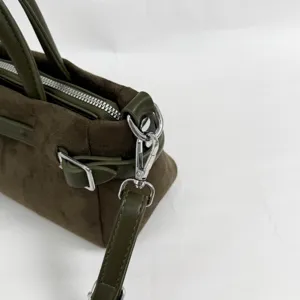Détail de sac à main en daim vert olive avec boucle de ceinture et quincaillerie argentée chic.