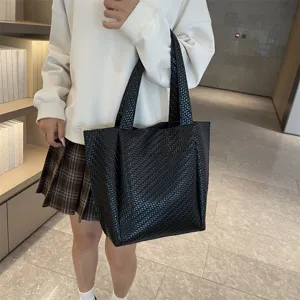 Black woven tote bag for women, stylish leather-look shoulder handbag for daily commuting.