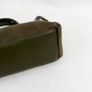 Gros-plan du sac à main en daim et cuir vert olive avec de belles coutures.