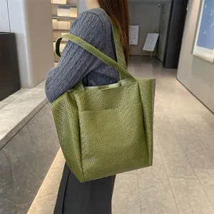 Green woven leather tote bag detail showing texture, stylish women shoulder handbag.