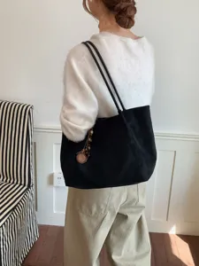 Detailansicht einer minimalistischen schwarzen Wildleder-Tragetasche im Alltag-Look.