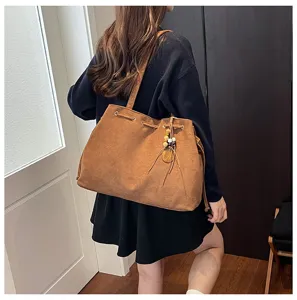 Braune Wildleder Tasche, große Umhängetasche mit Kordelzug und schönen Anhängern für Damen.