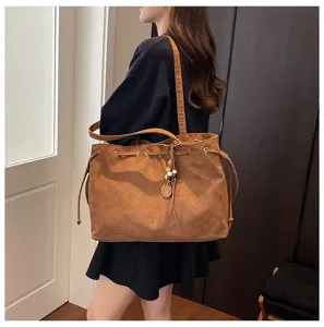 Braune Wildleder-Tasche für Damen, großer Shopper mit Kordelzug und stilvoller Quasten-Deko.
