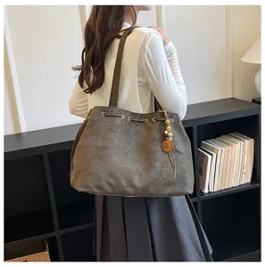 Detailansicht der großen Wildleder Schulter-Tote-Bag mit Tunnelzug und Perlen-Quasten-Anhänger.