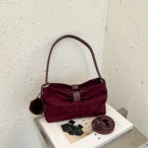 Bordeauxrode suède schoudertas met bontbal hanger, elegante handtas voor dagelijks gebruik.
