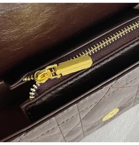 Nahaufnahme der luxuriösen gesteppten Ledertasche mit goldenem Reißverschluss und Beschlägen.