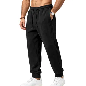 Men's black suede sweatpants detail view, showing elastic drawstring waist and cuffed hem.