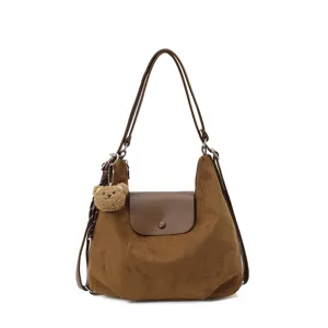 Brown suede shoulder bag with chic flap closure and cute plush bear charm for stylish daily wear.
