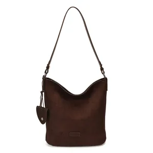 Brown suede shoulder bag detail showcasing soft texture and elegant strap craftsmanship.