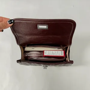 Dark brown quilted leather crossbody bag interior view showing compartments and storage.
