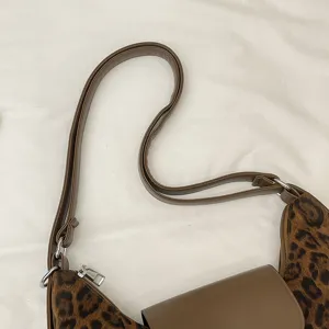Detailed view of the brown leopard print shoulder bag strap and flap, premium texture.