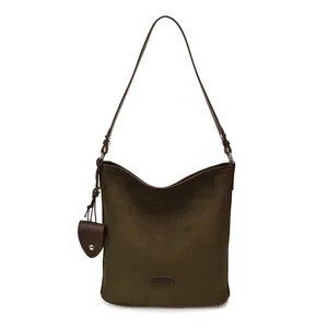 Dark green suede shoulder bag detail showing soft fabric and fine leather strap construction.