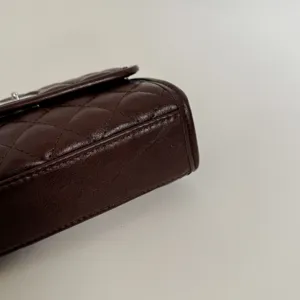 Brown quilted leather flap bag detail close up luxury shoulder cross body handbag minimalist style