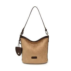 Detailed view of the retro brown suede bucket bag with dark trim and elegant shoulder strap.