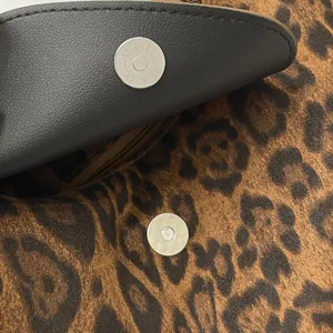 Detailed view of women's fashionable shoulder bag hardware and leopard print interior lining.