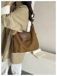 Brown suede shoulder bag detail showing premium texture, flip cover and cute bear pendant.