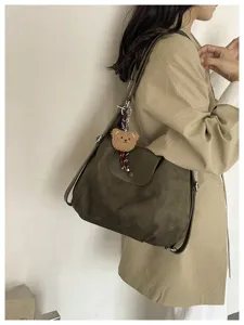 Fashionable solid color suede shoulder bag with cute bear pendant for women commuting daily