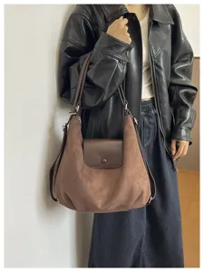 Detail view of brown suede shoulder bag, stylish casual handbag for women daily commute.