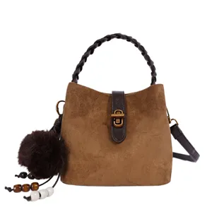 Borsa a secchiello in camoscio stile coreano con serratura metallica e manico intrecciato.