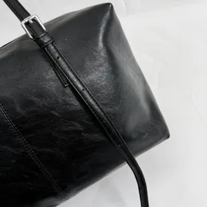 Close-up detail of black leather shoulder bag strap and texture, elegant retro fashion handbag.