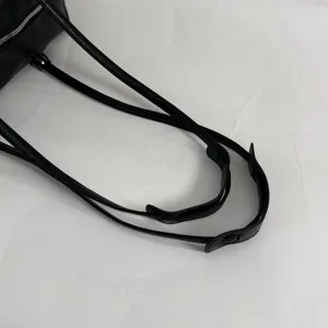 Black leather handbag strap detail, minimalist shoulder bag handle close-up craft design.