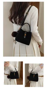 Dettaglio di una borsa a secchiello coreana vintage in camoscio nero con manico intrecciato.