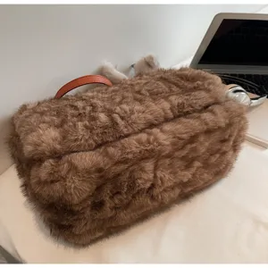 Gros plan détaillé du sac à bandoulière en peluche marron tendance à texture douce.