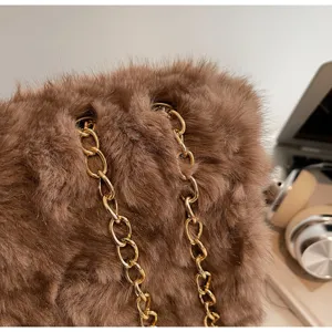 Détail de sac sous les bras en peluche marron, fausse fourrure douce avec élégante chaîne dorée.