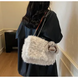 Détail arrière du sac porté épaule en peluche blanche douce avec chaîne métallique et lapin.