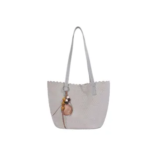 Grey woven suede shoulder bag with chic scalloped edge and wooden bead charm detail.