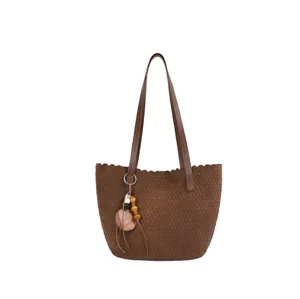 Brown woven shoulder bag detail, retro suede tote with wooden bead pendant and chic edges.