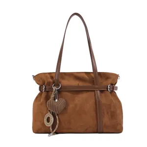 Braune Wildleder-Umhängetasche Detailansicht mit Ziergürtel und hängendem Herzanhänger.