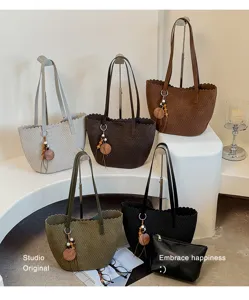 Stylish woven underarm shoulder bag with chic scalloped edge and wooden pendant detail.