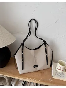 Λεπτομερής όψη vintage καμβά tote τσάντας με μαύρα λουράκια αντίθεσης και μεταλλικές αγκράφες.
