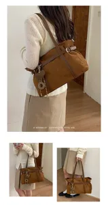 Detailansicht der Retro Wildleder Umhängetasche mit Metallanhänger und stilvollem Vibe.