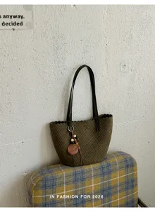 Close-up of the vintage woven velvet underarm bucket bag detail with stylish strap and charm.