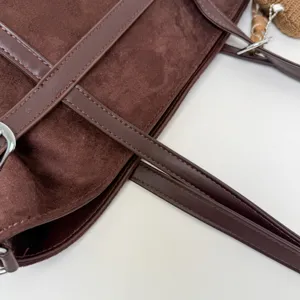 Nahaufnahme der Retro Wildleder Tasche mit PU Lederriemen, Silberschnalle und Strickanhänger.