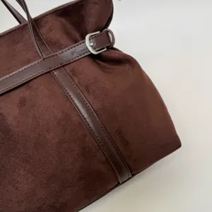 Braune Vintage-Wildleder-Shopper-Tasche Detail mit Kunstlederriemen und Metallschnalle.