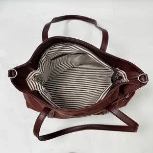Detailansicht der braunen Wildleder-Tasche Innenfutter mit Streifen und Reißverschluss.