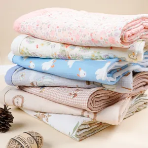 Detailed view of stacked 4-layer pure cotton gauze baby blankets, soft and cozy fabric.