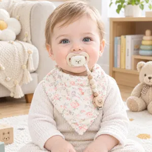 Detail shot of baby floral gauze bib with cute wooden pacifier clip in cozy room setup