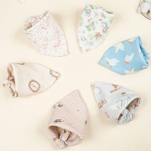 Detailed close-up of soft double-layer cotton gauze baby bibs featuring cute print designs.